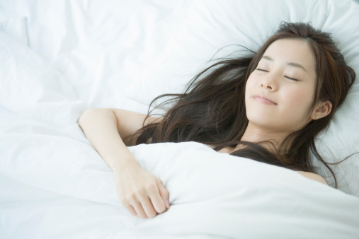 Young woman sleeping on bed, portrait