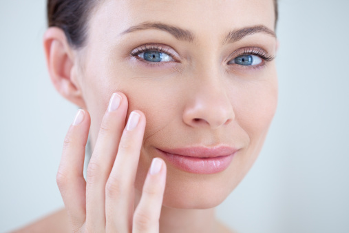 Woman examining her face with her fingers